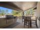 Covered patio with a built-in outdoor kitchen including a grill, countertop, and seating at 5787 Powell Rd, Parker, CO 80134