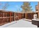 Private backyard with wooden fence and snowy ground at 9105 Oberon Rd # 2, Arvada, CO 80004