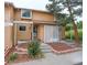 Tan two-story townhouse exterior with landscaping and a white lattice at 9105 Oberon Rd # 2, Arvada, CO 80004