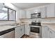 Modern kitchen with stainless steel appliances and gray cabinets at 9105 Oberon Rd # 2, Arvada, CO 80004