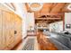 Grand entrance foyer showcasing hardwood floors, wooden beam ceiling, and a view into the open concept kitchen at 4491 Shoshone Dr, Larkspur, CO 80118