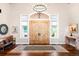Inviting foyer with hardwood flooring, a chandelier, and views of the front door at 4491 Shoshone Dr, Larkspur, CO 80118