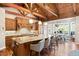 Spacious eat-in kitchen with granite island, stainless appliances, wood beams, and ample natural light at 4491 Shoshone Dr, Larkspur, CO 80118