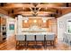 Spacious kitchen with wooden beam ceiling, granite counters, stainless appliances, and hardwood flooring at 4491 Shoshone Dr, Larkspur, CO 80118