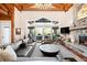 Open-concept living room with a stone fireplace, hardwood floors, and access to an outdoor patio at 4491 Shoshone Dr, Larkspur, CO 80118