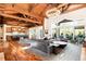 Open-concept living room with hardwood floors, access to an outdoor patio, and a view of the kitchen at 4491 Shoshone Dr, Larkspur, CO 80118