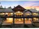Rear exterior featuring a multi-level deck with stone columns and a well-maintained backyard at 4491 Shoshone Dr, Larkspur, CO 80118