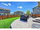 Relaxing backyard with a stone patio, seating, grill, green lawn, and a wood fence surrounding the perimeter at 7888 E 139Th Pl, Brighton, CO 80602