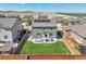 Aerial view of a backyard with a well-maintained lawn, patio area, and privacy fence at 7888 E 139Th Pl, Brighton, CO 80602