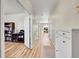 Long hallway featuring wood floors, white doors, neutral paint color, and modern lighting, seamlessly connecting living spaces at 7888 E 139Th Pl, Brighton, CO 80602
