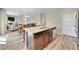 Open floor plan featuring a kitchen island with wooden cabinets, stainless appliances, and a view of the dining/living area at 7888 E 139Th Pl, Brighton, CO 80602