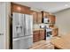 Beautiful kitchen with stainless steel refrigerator, gas range, granite countertops, wood cabinets and wood laminate flooring at 7888 E 139Th Pl, Brighton, CO 80602