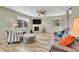 Bright living room features wood floors, a ceiling fan, and a cozy fireplace at 7888 E 139Th Pl, Brighton, CO 80602