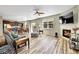 Spacious living room with fireplace and wood floors seamlessly connects to the kitchen and dining area at 7888 E 139Th Pl, Brighton, CO 80602