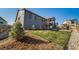Landscaped backyard with a view of the deck, wooden fence, and neighboring houses under a clear sky at 1087 E Hopkins Dr, Elizabeth, CO 80107