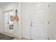 Bright foyer featuring light walls, a wood floor, coat rack and view to the office at 1087 E Hopkins Dr, Elizabeth, CO 80107