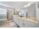 The main bathroom features double sinks, white cabinets, a large mirror, a bathtub, and a shower at 1087 E Hopkins Dr, Elizabeth, CO 80107