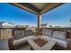 Inviting covered patio with comfortable seating, a cozy fire pit, and neighborhood views at 1087 E Hopkins Dr, Elizabeth, CO 80107