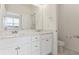 Bright bathroom with double sinks, white cabinets, and a marble countertop at 6804 Merseyside Ln, Castle Pines, CO 80108
