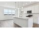 Modern kitchen features white cabinets, stainless steel appliances, island with quartz countertop, and natural light from large windows at 6804 Merseyside Ln, Castle Pines, CO 80108