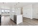 Open kitchen with island, stainless steel appliances, modern fixtures, and wood-look floors offers extra counter space at 6804 Merseyside Ln, Castle Pines, CO 80108