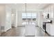 Bright kitchen with white cabinets, stainless steel appliances, island, and large window offering city views at 6804 Merseyside Ln, Castle Pines, CO 80108