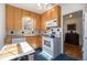 Efficient kitchen with wooden cabinets, white appliances, and a view of the dining room at 1235 S Josephine St, Denver, CO 80210