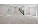 View of carpeted basement with staircase and window, neutral gray walls, and white trim, providing a clean aesthetic at 5905 S Platte Canyon Dr, Littleton, CO 80123