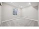 View of carpeted basement with window, neutral gray walls, and white trim, providing a clean and modern aesthetic at 5905 S Platte Canyon Dr, Littleton, CO 80123