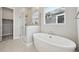 Modern bathroom featuring a soaking tub and a glass-enclosed shower with modern fixtures at 5905 S Platte Canyon Dr, Littleton, CO 80123