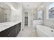 Stylish bathroom featuring a soaking tub, glass enclosed shower, and double vanity sinks at 5905 S Platte Canyon Dr, Littleton, CO 80123