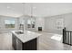 Bright, open-concept kitchen featuring a large island, modern lighting, and stainless steel appliances at 5905 S Platte Canyon Dr, Littleton, CO 80123