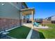 Well-maintained backyard with a covered patio, fire pit, and artificial turf area for recreation and leisure at 26909 E Cedar Ave, Aurora, CO 80018