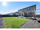 Spacious backyard with a well-kept lawn, fire pit area, and fenced perimeter for privacy and security at 26909 E Cedar Ave, Aurora, CO 80018