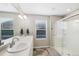 Bright bathroom featuring double sinks, a glass-enclosed shower, and a bright window, providing a serene atmosphere at 26909 E Cedar Ave, Aurora, CO 80018