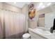 Bathroom features a shower, toilet, sink, mirror, and patriotic decorations at 26909 E Cedar Ave, Aurora, CO 80018