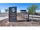 Welcoming community entrance with a modern sign, lush landscaping, and a glimpse of the community amenities at 26909 E Cedar Ave, Aurora, CO 80018