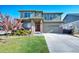 Charming two-story home with a well-manicured lawn, a driveway, and a beautiful flowering tree in the front yard at 26909 E Cedar Ave, Aurora, CO 80018