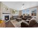 Cozy living room with a stone fireplace, neutral walls, hardwood floors, and a comfortable, plush sectional couch at 26909 E Cedar Ave, Aurora, CO 80018