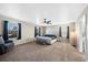 Spacious main bedroom features carpet flooring, ample natural light, a ceiling fan, and a comfortable seating area at 26909 E Cedar Ave, Aurora, CO 80018