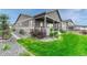 Charming backyard with a covered patio, lush green lawn, and landscaped garden beds for serene outdoor living at 2932 Eagle Wing Way, Castle Rock, CO 80109