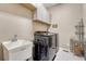 Convenient laundry room includes modern washer and dryer, storage and sink at 2932 Eagle Wing Way, Castle Rock, CO 80109