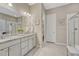 Bright bathroom features double vanity, granite countertop, and tiled shower with glass door at 2932 Eagle Wing Way, Castle Rock, CO 80109