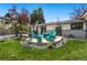 Landscaped backyard featuring a patio area, stylish outdoor furniture, mature trees, and manicured lawn at 6439 E Maplewood Ave, Centennial, CO 80111