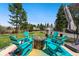 Inviting backyard patio featuring a cozy fire pit and Adirondack chairs, perfect for outdoor entertaining and relaxation at 6439 E Maplewood Ave, Centennial, CO 80111