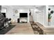 Basement area features exercise equipment, a large television, storage space, and access to the staircase at 6439 E Maplewood Ave, Centennial, CO 80111