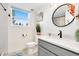Bright bathroom showcasing a modern vanity with quartz countertop, round mirror, and a shower with glass door at 6439 E Maplewood Ave, Centennial, CO 80111
