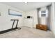 Minimalist bedroom setup with a treadmill, white dresser, and natural light coming through a window at 6439 E Maplewood Ave, Centennial, CO 80111