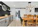 Stylish dining room features a wood table, trendy light fixture, and gray built-in cabinets with a drink fridge at 6439 E Maplewood Ave, Centennial, CO 80111