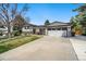 Well-maintained home featuring a spacious driveway and manicured lawn at 6439 E Maplewood Ave, Centennial, CO 80111